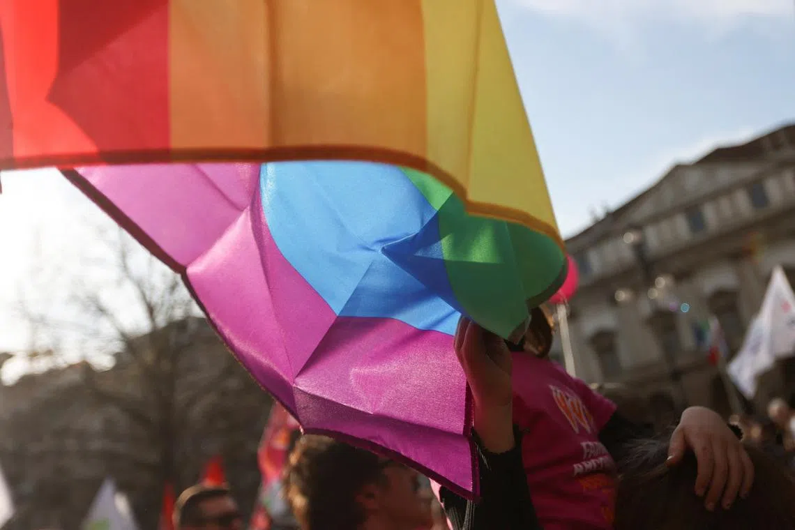 A child of a same-sex couple touches the LGBT flag at a protest after Italy's right-wing government told Milan's city council to stop registering same-sex parents' children in Milan, Italy March 18, 2023. REUTERS/Claudia Greco
