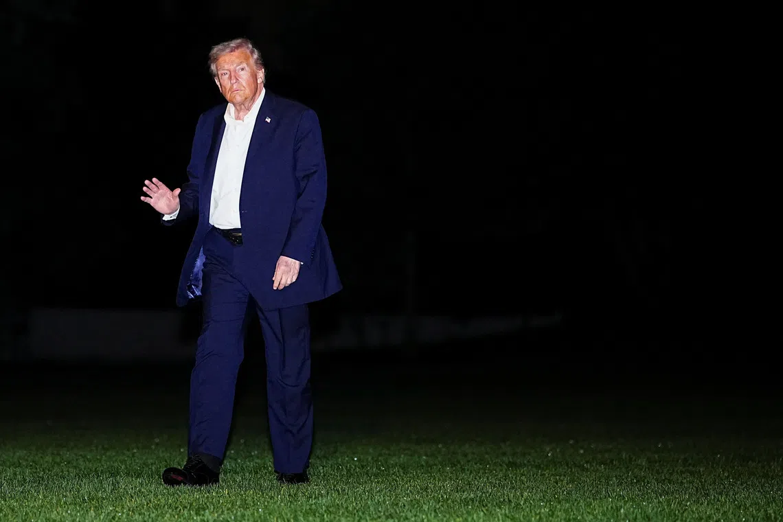 U.S. President Donald Trump waves while walking on the South Lawn as he arrives back at the White House, after participating in a world leaders' summit in Egypt on ending the Gaza war, amid a ceasefire between Israel and Hamas in Gaza, in Washington, D.C., U.S., October 14, 2025. REUTERS/Aaron Schwartz