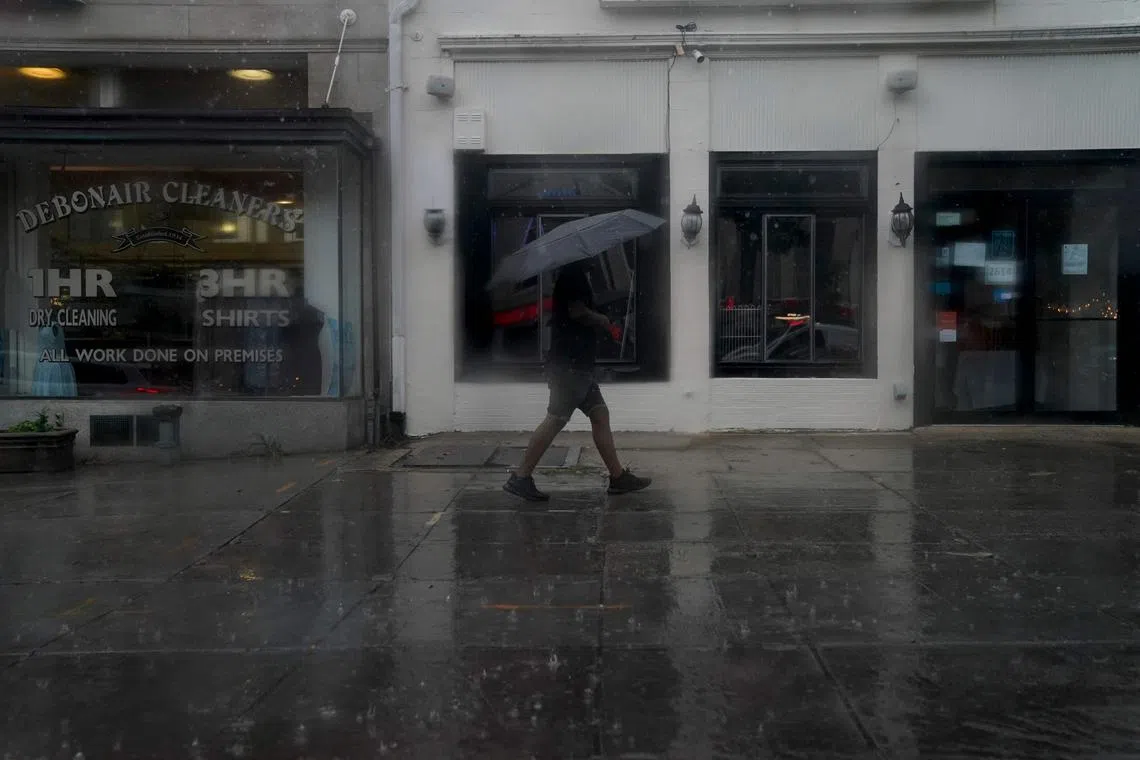A pedestrian carries an umbrella while walking through rain in Washington DC, on Monday. A tornado watch is in effect for the area, with heavy rain, strong winds, and hail expected. 