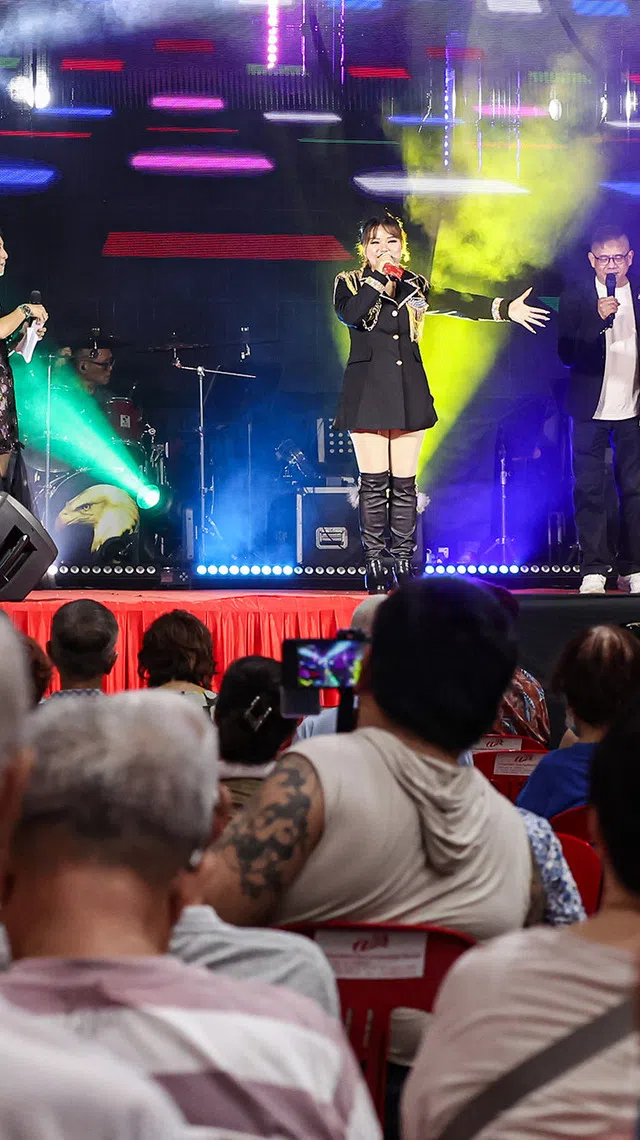Getai hosts  Ke Le (left) and Jacky Chin (right) interacting with getai singer Lin Jia Jia (centre) on stage at a hungry ghost festival getai show at Toa Payoh Industrial Park on Aug 20, 2026. ST PHOTO: BRIAN TEO