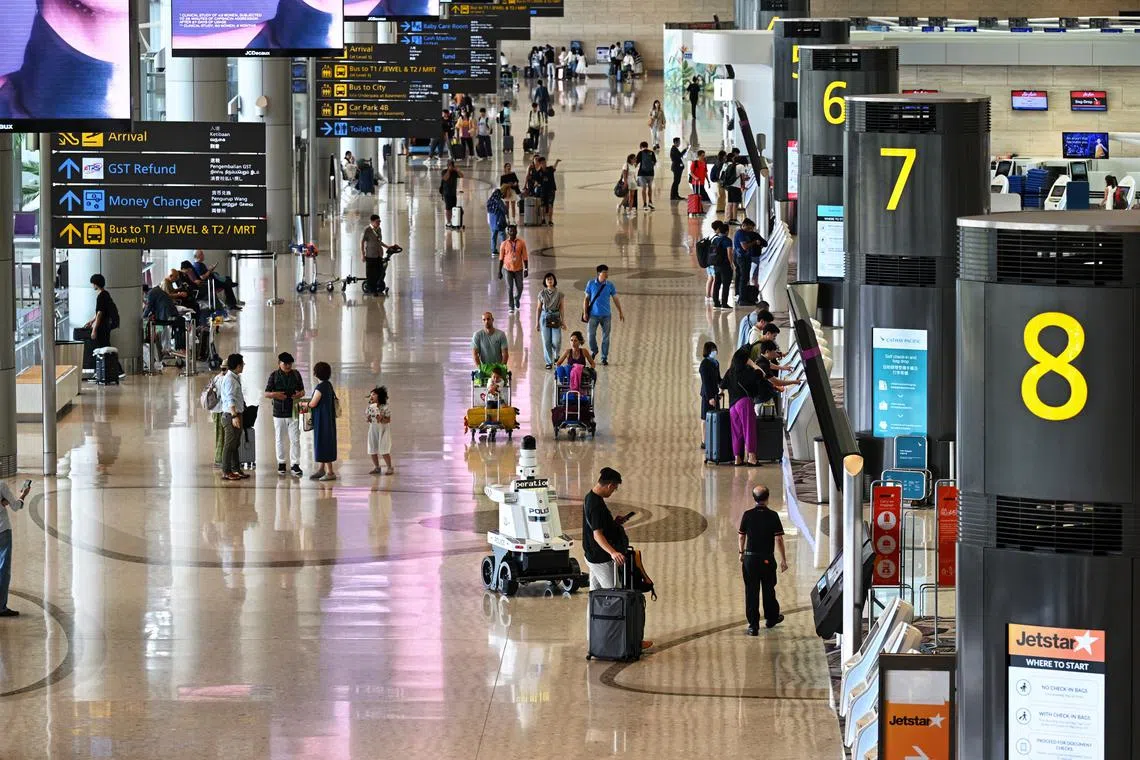 Generic photo of passengers in the departure hall with a Police patrol robot at Changi Airport Terminal 4 taken on Oct 29, 2024. Can be used for travel, airline, airfare stories.