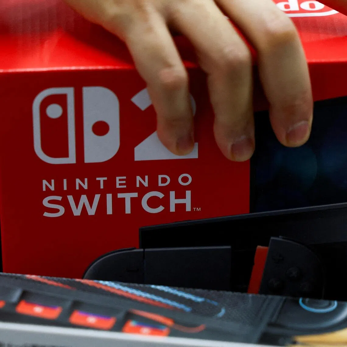 FILE PHOTO: A person holds a Nintendo Switch 2 game console's box as Nintendo starts selling the new consoles globally, at an electronics store in Tokyo, Japan June 5, 2025.  REUTERS/Issei Kato/File Photo