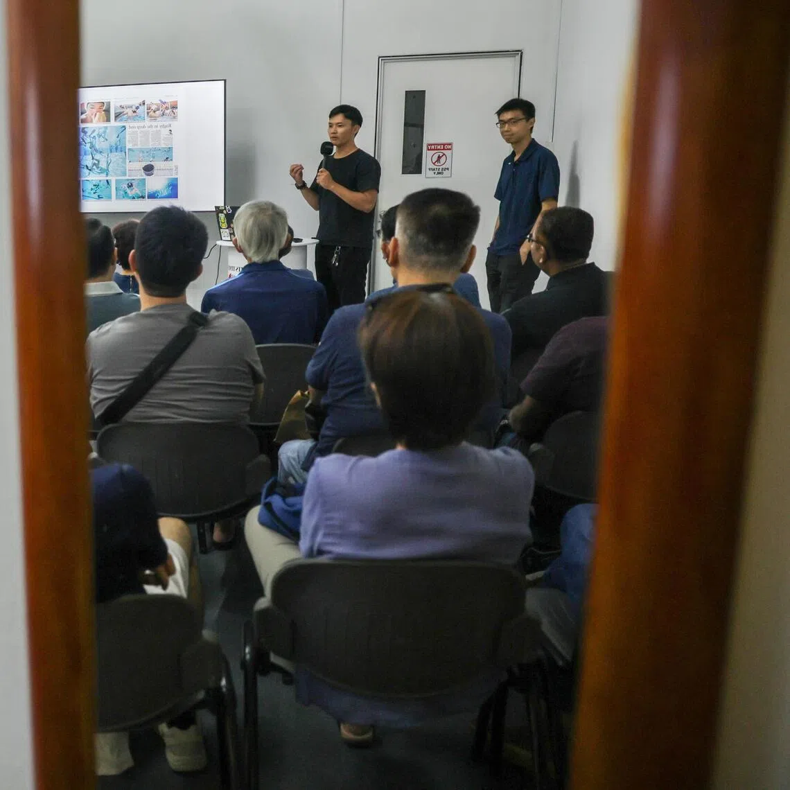 The Straits Times photojournalists Mark Cheong (standing, left) and Brian Teo during their talk, Finding Singapore Stories, at the ST180 Photo Exhibition on Nov 15.