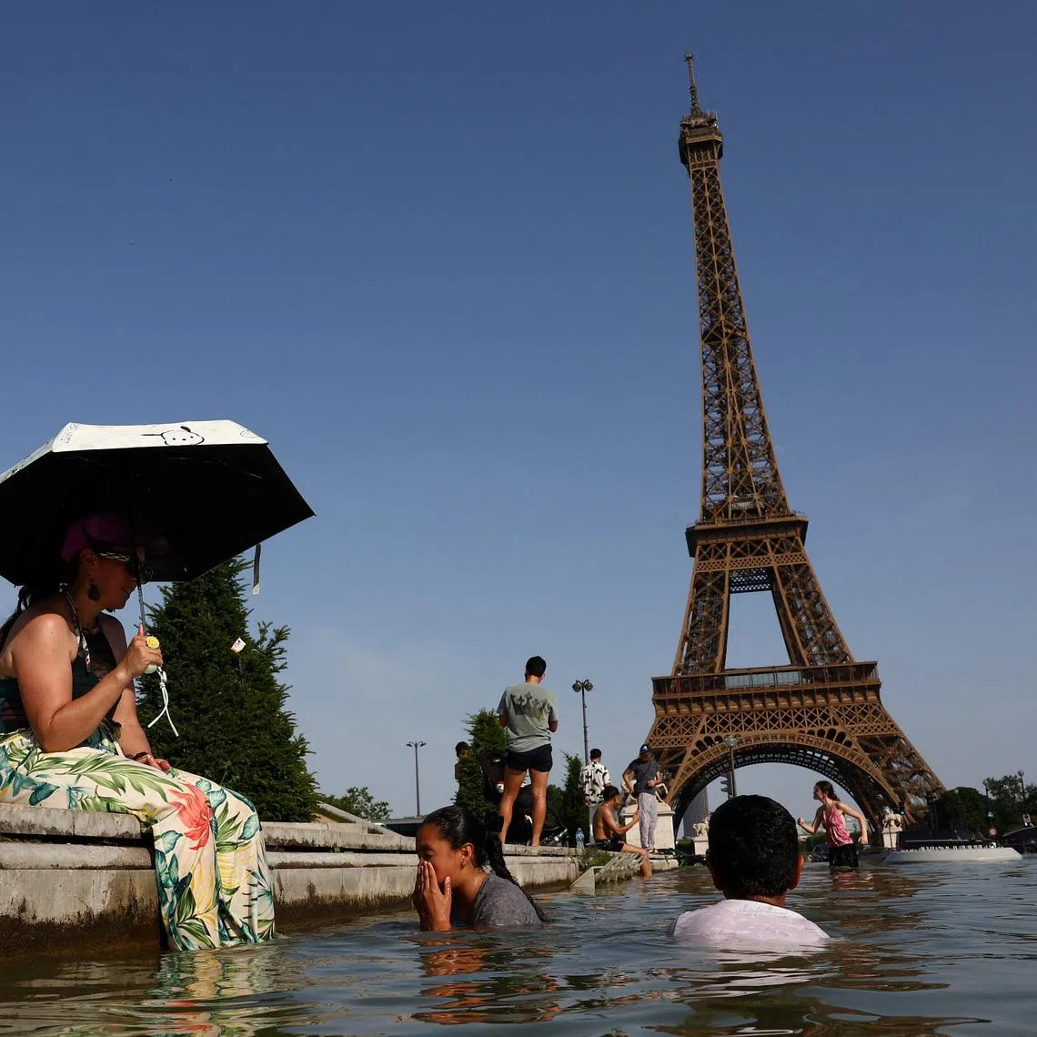 People cool off in the Trocadero fountain in front of the Eiffel Tower as temperatures rise in Paris during a heatwave affecting a large part of France, June 23, 2026. REUTERS/Abdul Saboor