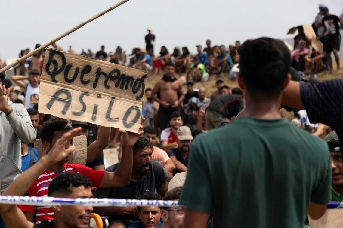 A migrant holding a sign reading “We want asylum”, in Spanish, on Aug 16, in Spain’s north African enclave of Ceuta.