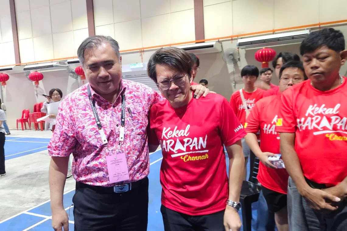 DAP secretary general Anthony Loke (left) is consoling one of his tearing campaign team members at a counting centre, after conceding defeat in Chennah, Negeri Sembilan.