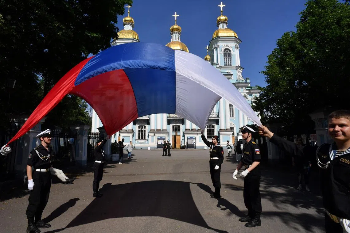 Russian navy recruits holding a Russian flag during a ceremony marking the departure of recruits to join the army in St Petersburg on June 4. Amid the ongoing war with Ukraine, Moscow has turned to recruiting prisoners, both male and female, to aid the war effort.