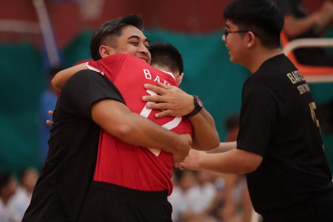 Muhammad Nor Aniq Mohamad Nazri (#12) hugs his coach, Rithwan Kassim, after Bartley Secondary School won the B Division Boys sepak takraw finals at the Ministry of Education’s (MOE) Physical, Sports and Outdoor Education Branch on Thursday. After losing the first regu, Bartley beat Woodlands by a score of 2-1.
