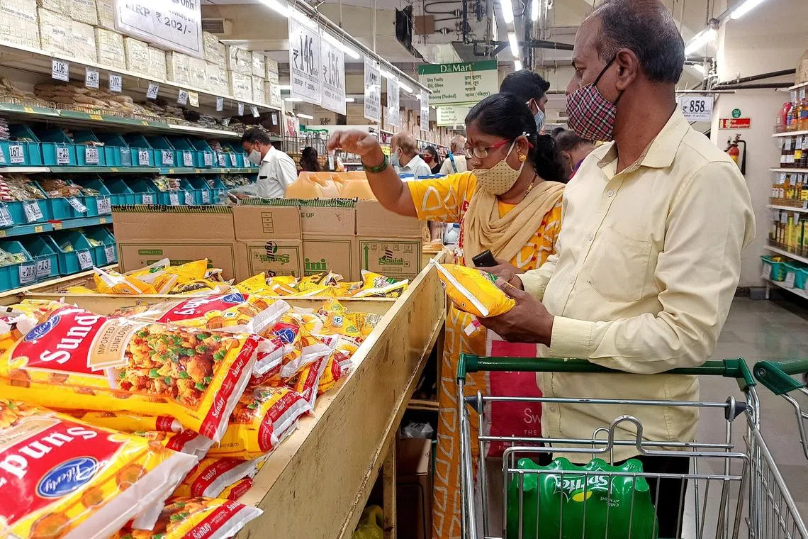 FILE PHOTO: Shoppers purchase packets of vegetable oil at a supermarket in Mumbai, India, March 7, 2022. REUTERS/Rajendra Jadhav/File Photo