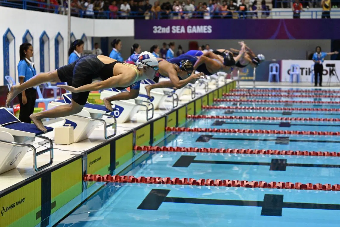 Malaysia's Tan Rouxin (left) dives in with other competitors at the start of the women's 50m breaststroke final at the 32nd SEA Games in Phnom Penh.