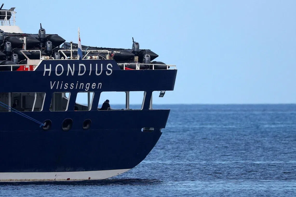 A large dark blue ship named Hondus is sailing on the water.