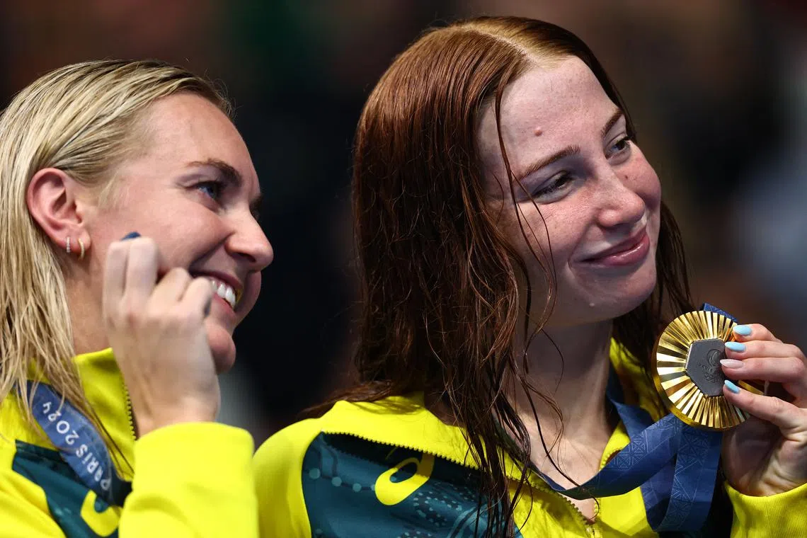 Paris 2024 Olympics - Swimming - Women's 200m Freestyle Victory Ceremony - Paris La Defense Arena, Nanterre, France - July 29, 2024. Gold medallist Mollie O'Callaghan of Australia celebrates on the podium after winning with silver medallist Ariarne Titmus of Australia. REUTERS/Ueslei Marcelino