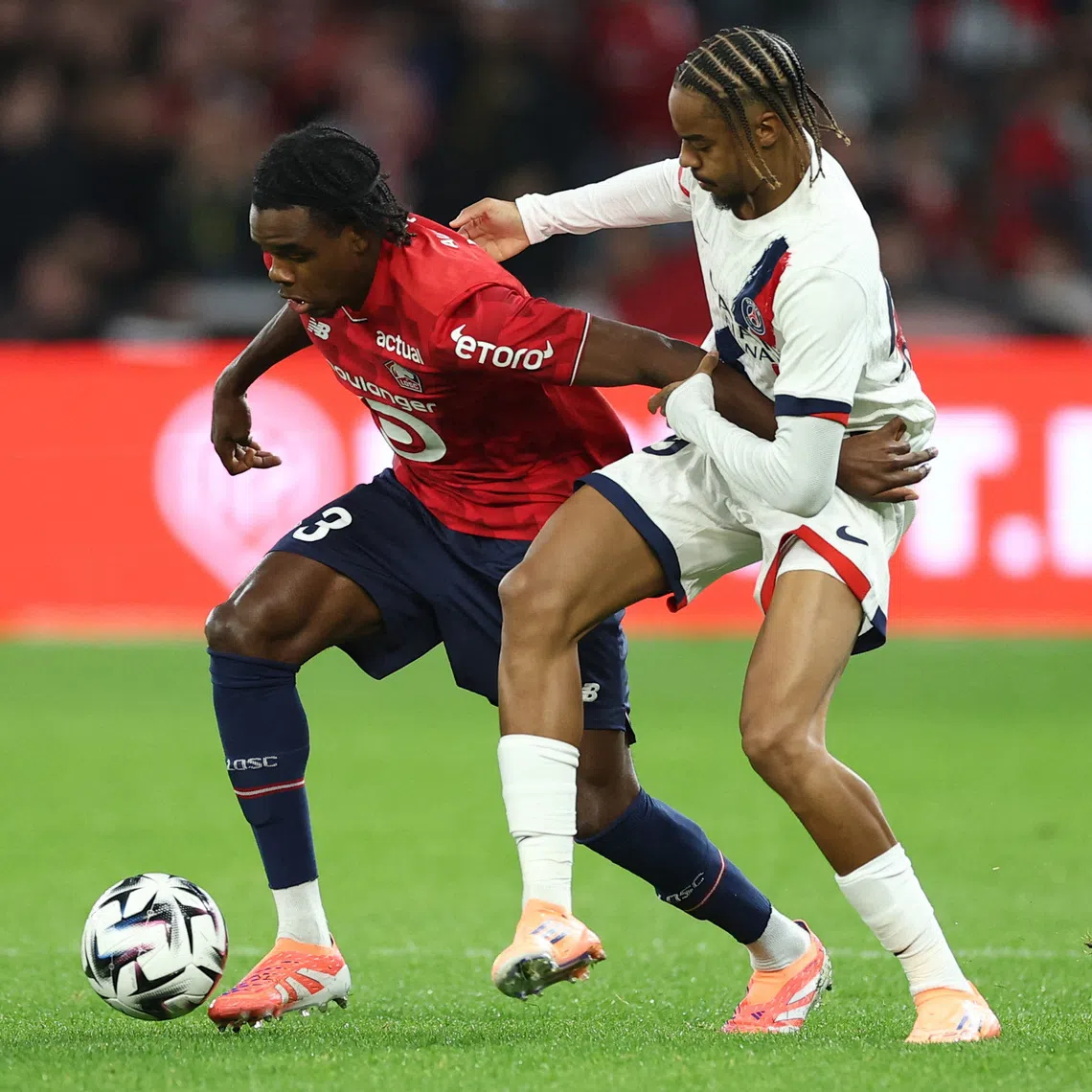 Soccer Football - Ligue 1 - Lille v Paris St Germain - Decathlon Arena Stade Pierre-Mauroy, Villeneuve-d'Ascq, France - October 5, 2025 Lille's Nathan Ngoy in action with Paris St Germain's Bradley Barcola REUTERS/Gonzalo Fuentes