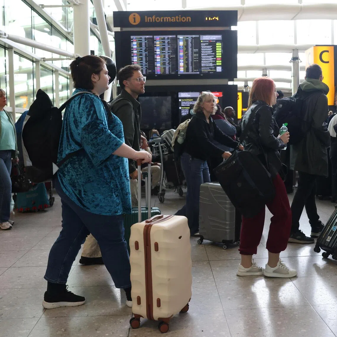 Passengers wait at a departure lounge at Heathrow Airport after a “technical issue” forced the cancellation of more than 1,300 flights.