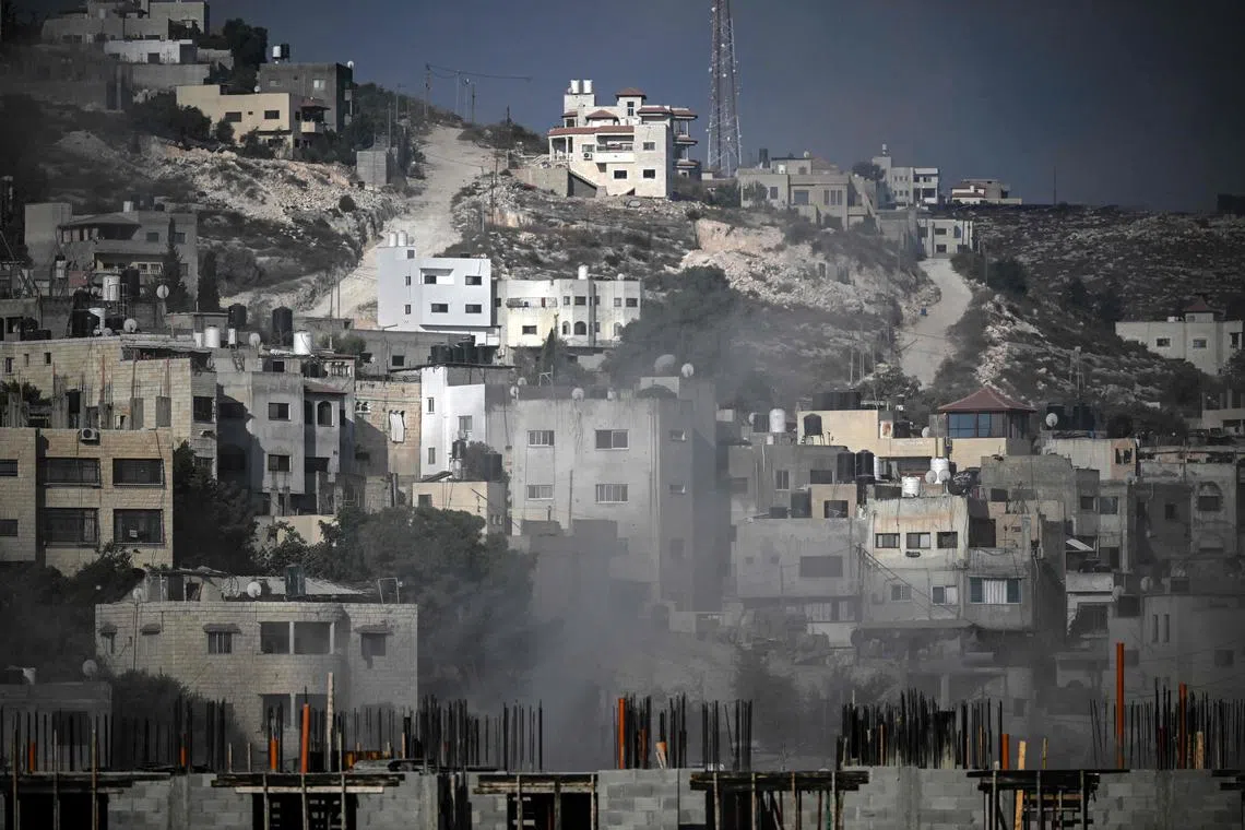 Smoke rises among buildings during an Israeli army raid in Jenin in the occupied West Bank on Aug 30, 2024. 