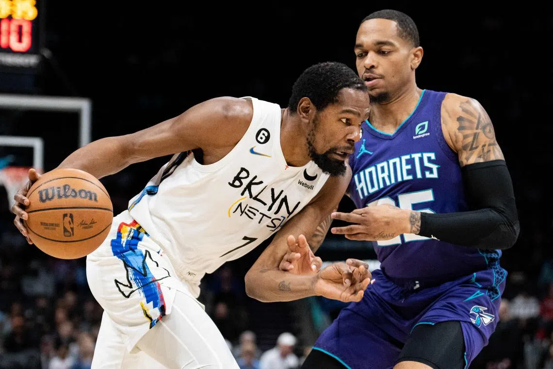 P. J. Washington of the Charlotte Hornets guarding Kevin Durant of the Brooklyn Nets in the first quarter during their game at Spectrum Centre on Saturday. Durant scored 23 points as the Nets won their 11th game in a row by routing the Hornets 123-106.