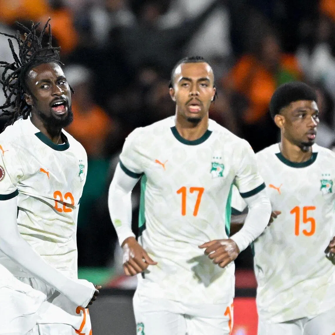 Ivory Coast forward Evann Guessand (left) celebrates scoring his team's equaliser with defender Guela Doue and forward Amad Diallo.