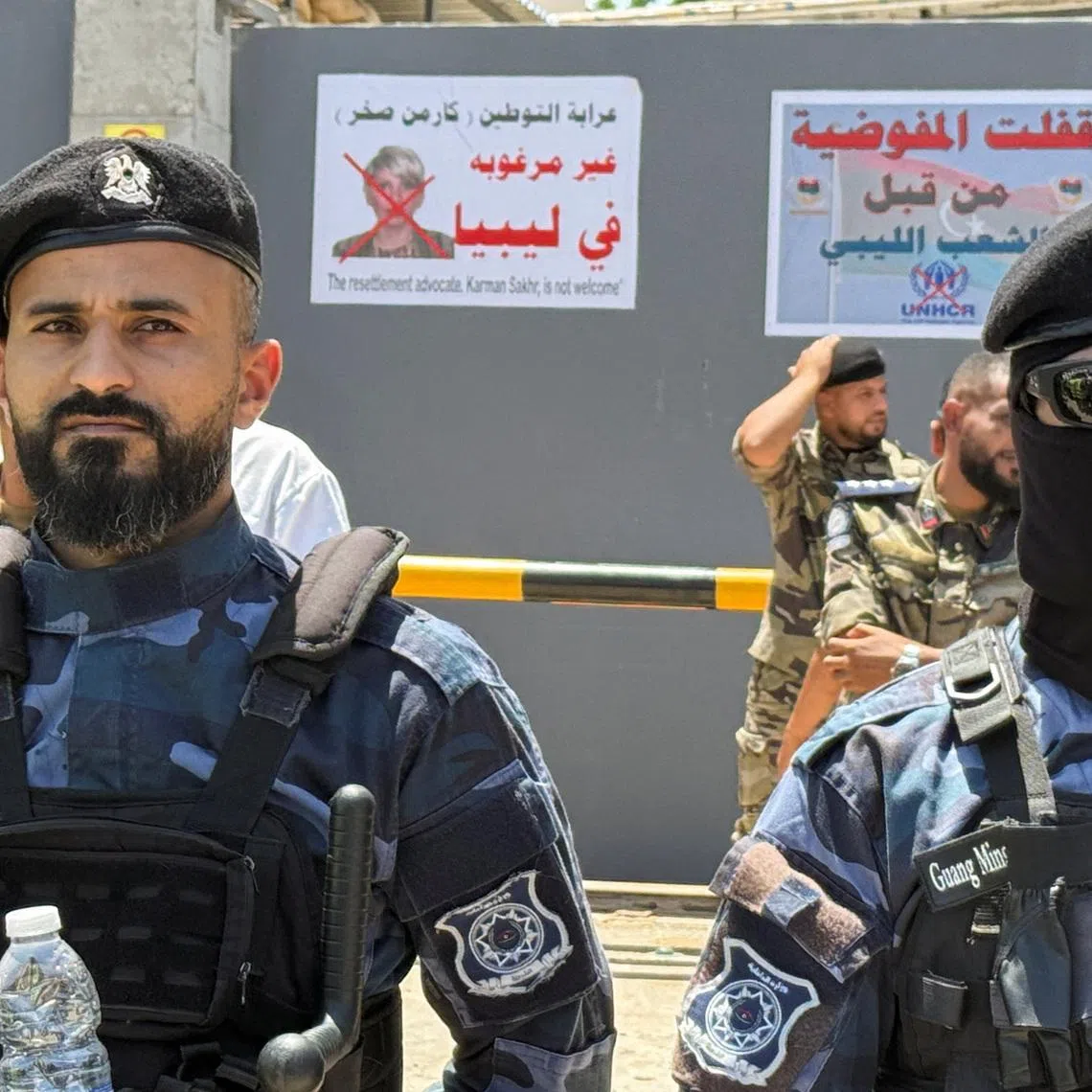 Security personnel stand guard as protesters gather outside the headquarters of the United Nations High Commissioner for Refugees (UNHCR), demanding the organisation leave the country and calling for an end to migrant settlement and the deportation of migrants and refugees, in Tripoli, Libya, June 4, 2026. Picture taken with a mobile phone. REUTERS/Ayman al-Sahili