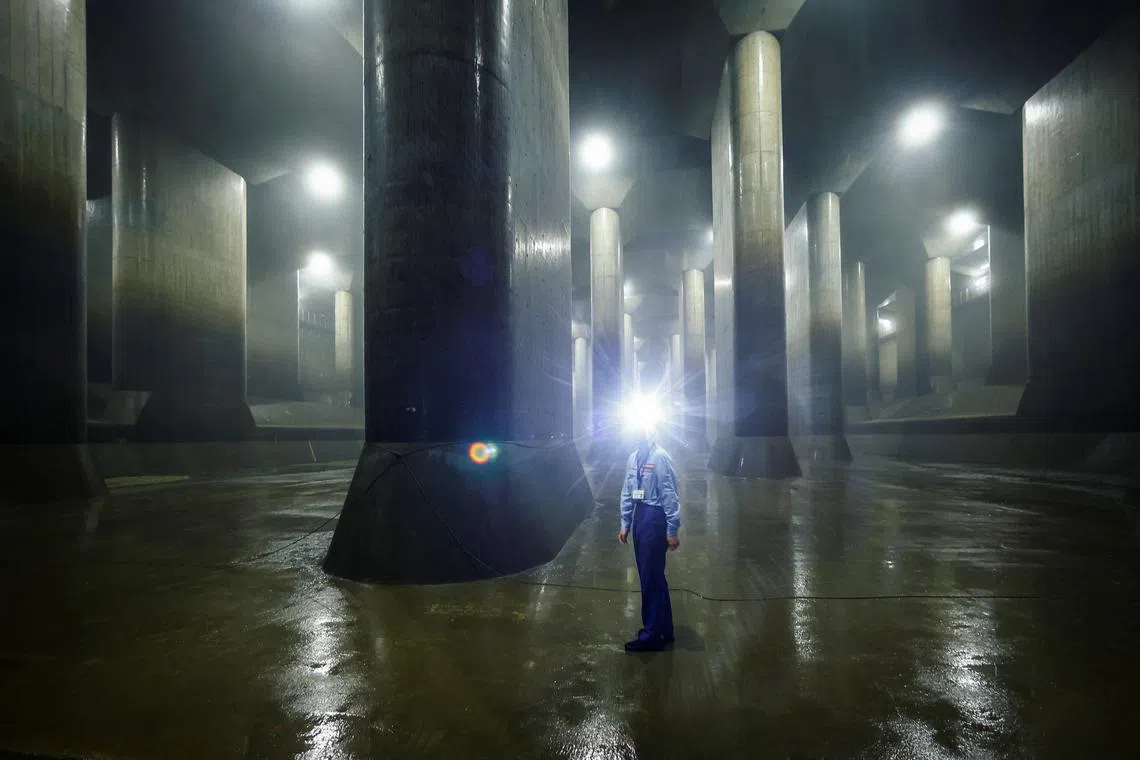 A staff member of Metropolitan Outer Floodway Management Office demonstrates how to perform check-ups inside a pressure-adjusting water tank, part of a complex of underground water discharge tunnels constructed to protect Tokyo and its suburbs against floods during heavy rain and typhoon seasons, at the Metropolitan Outer Area Underground Discharge Channel in Kasukabe, Japan, July 4, 2024. REUTERS/Issei Kato