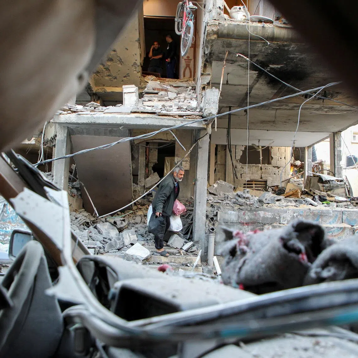 FILE PHOTO: A Palestinian man carrying belongings leaves a house hit in an Israeli strike, amid the ongoing conflict between Israel and the Palestinian Islamist group Hamas, in Rafah, in the southern Gaza Strip May 9, 2024. REUTERS/Hatem Khaled/File Photo