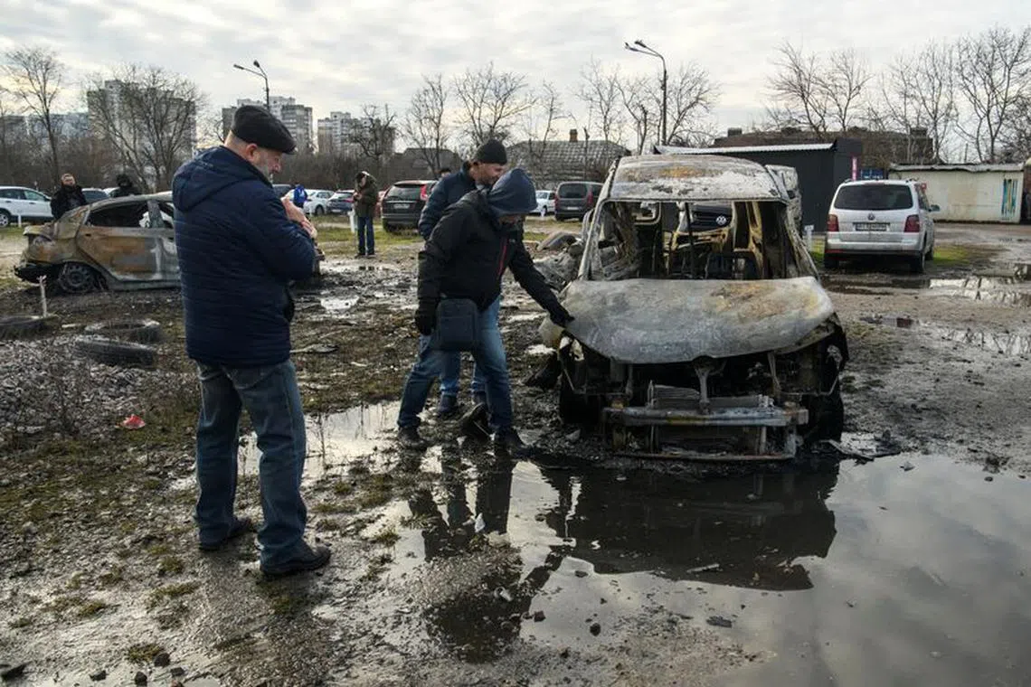 People inspect cars destroyed during a Russian missile and drone strike, amid Russia's attack on Ukraine, in Kyiv, Ukraine December 29, 2023. REUTERS/Vladyslav Musiienko