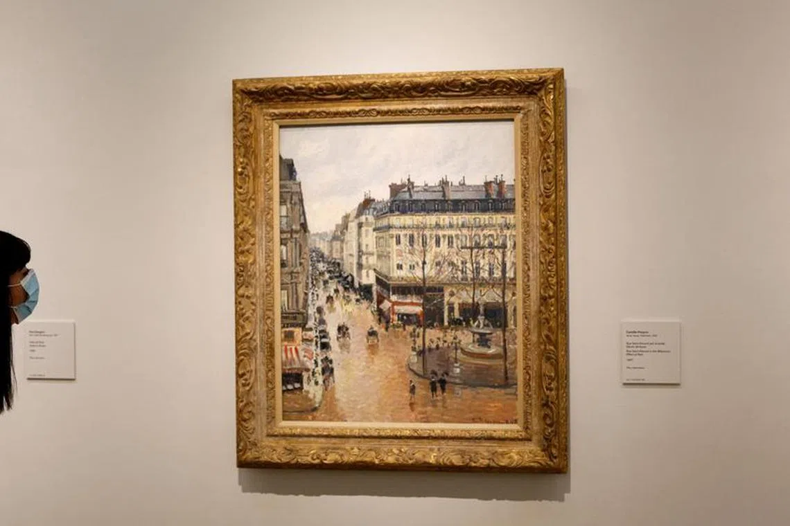 FILE PHOTO: A visitor leans to look at Camille Pissarro's \"Rue Saint-Honore in the Afternoon. Effect of Rain, 1897\" at Thyssen-Bornemisza museum in Madrid, Spain, April 22, 2022. REUTERS/Susana Vera/File Photo