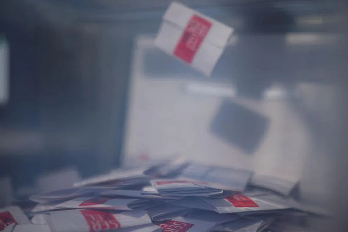 A ballot falls into a ballot box during a referendum on a new Chilean constitution, in Santiago, Chile, December 17, 2023. REUTERS/Pablo Sanhueza