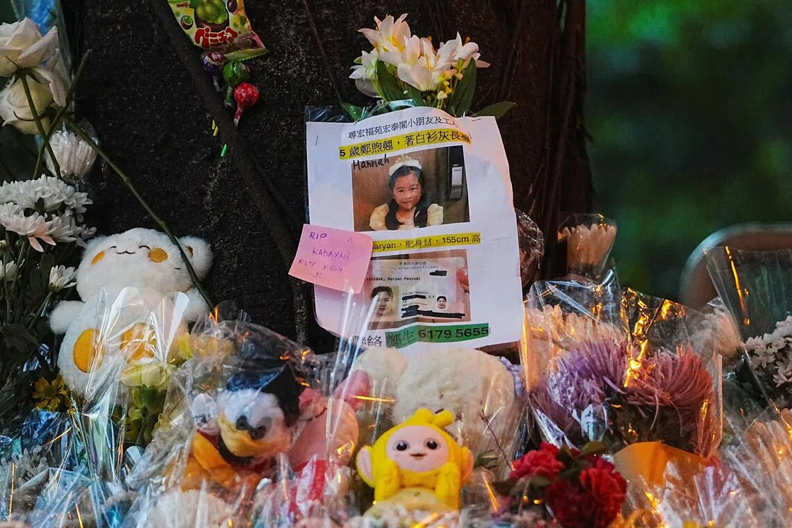 A missing person’s poster is placed at a makeshift memorial for victims of the deadly fire that gutted the Wang Fuk Court housing complex.
