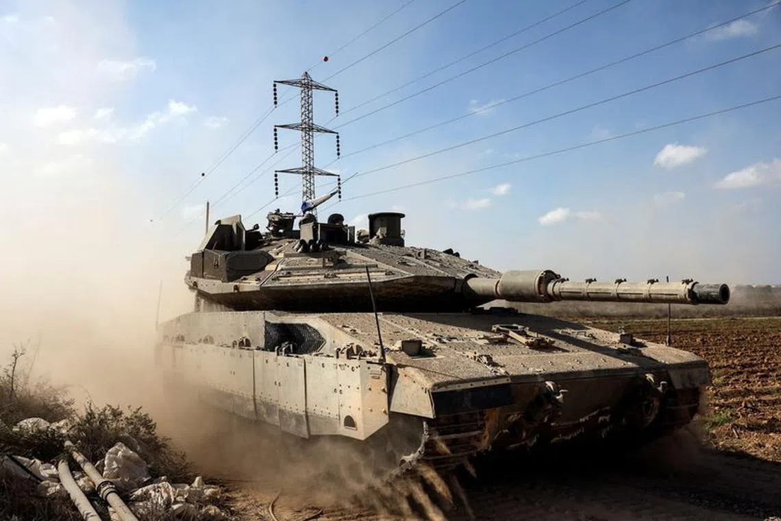 An Israeli tank takes up position near Israel's border with the Gaza Strip, in southern Israel, October 13, 2023. REUTERS/Violeta Santos Moura