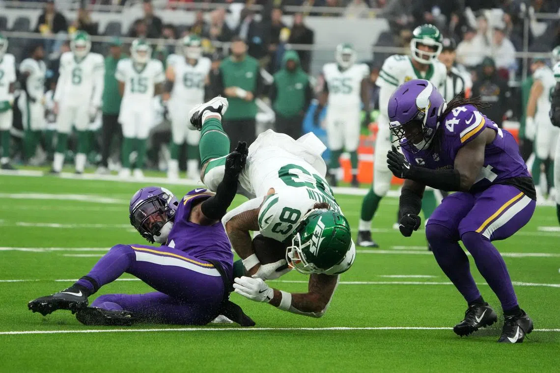 New York Jets tight end Tyler Conklin is tackled by Minnesota Vikings cornerback Shaquill Griffin and safety Josh Metellus in the second half at Tottenham Hotspur Stadium.