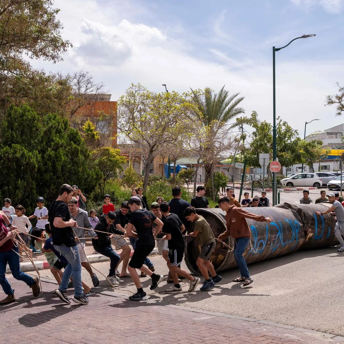 Children moving part of an Iranian missile remnant that fell in a school courtyard in the Israeli settlement of Peduel, in the occupied West Bank on March 23. Iran has been firing barrages of missiles at Israel in response to the bombing campaign by Israel and the United States that started on Feb 28, following the killing of the country's supreme leader. 