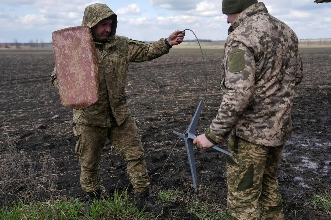 Ukrainian servicemen setting up a Starlink satellite internet terminal, amid Russia's invasion of Ukraine, near the front-line town of Pokrovsk, in Ukraine's Donetsk region, in April 2025.