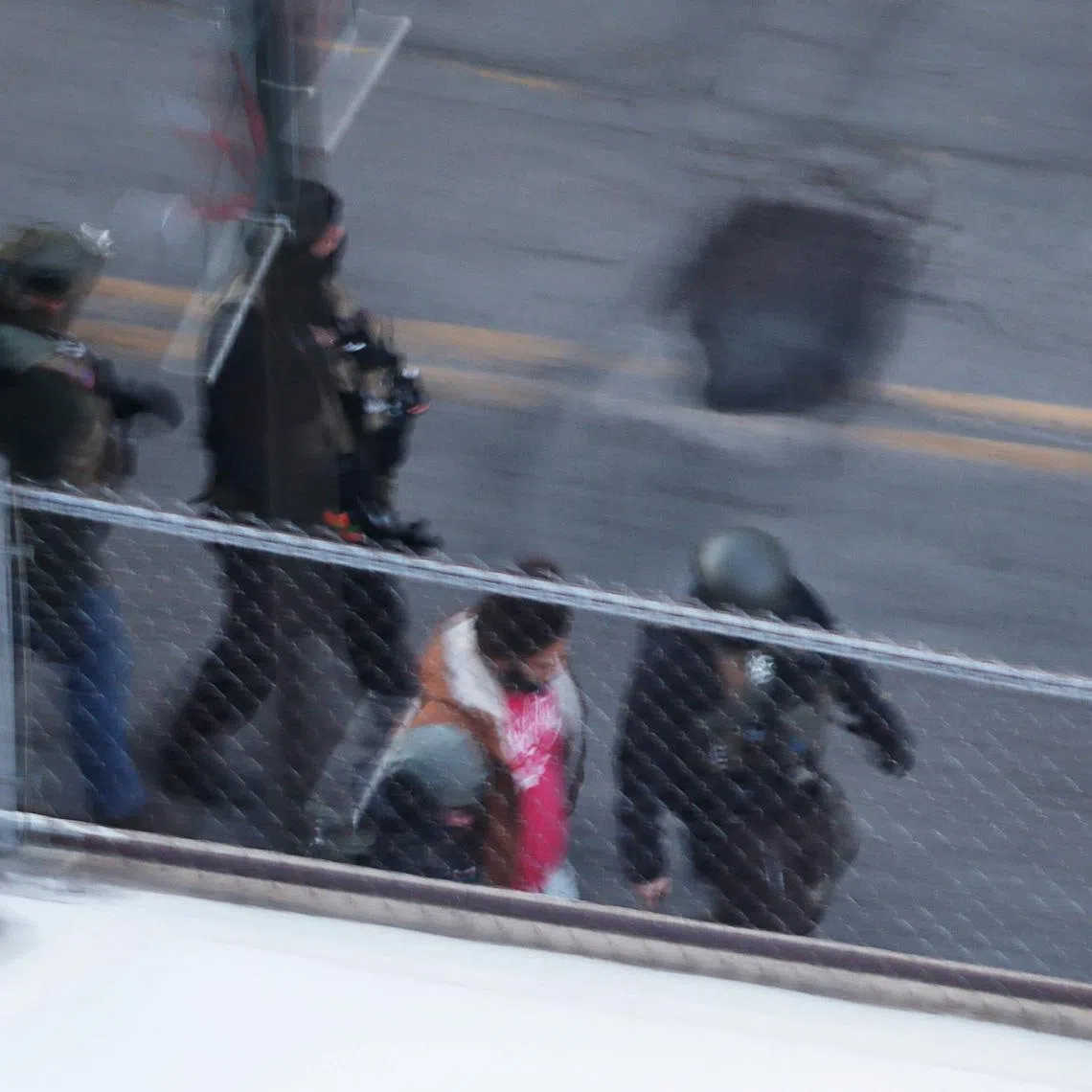 Federal immigration enforcement agents detain a person from an apartment building, days after a man identified as Alex Pretti was fatally shot by federal immigration agents trying to detain him, in Minneapolis, Minnesota, U.S., January 28, 2026.   REUTERS/Brian Snyder