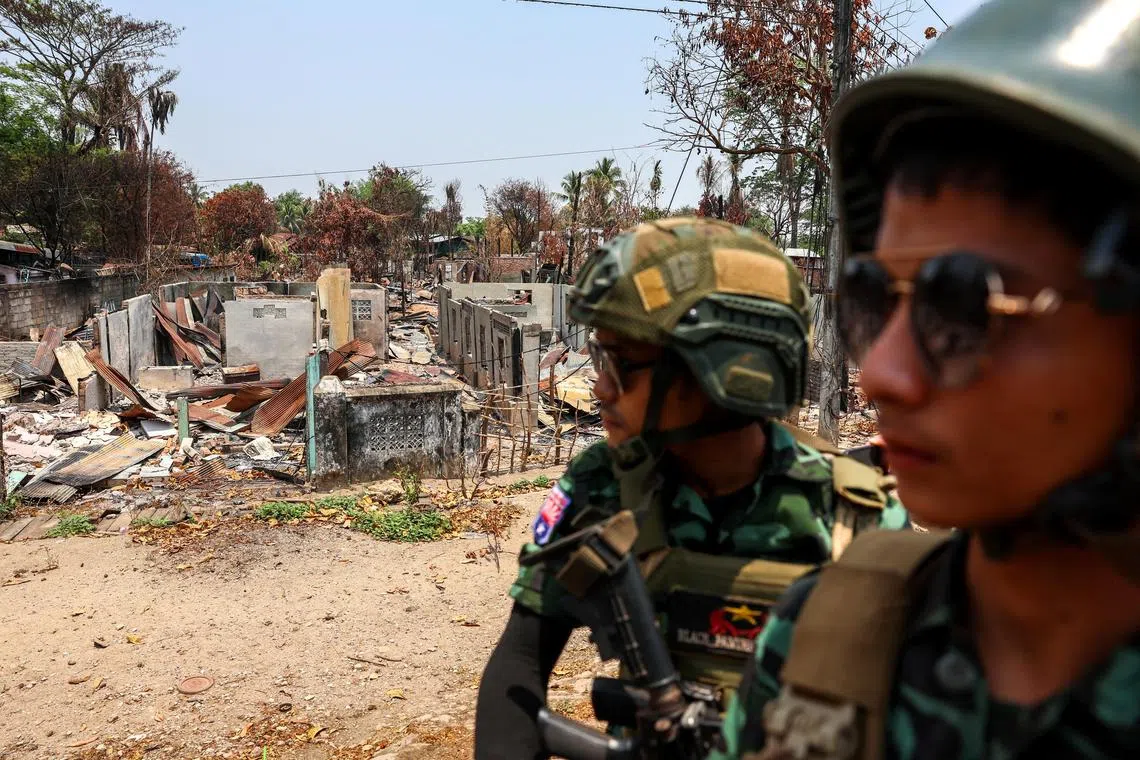 Soldiers from the Karen National Liberation Army (KNLA) patrolling on a vehicle, next to an area destroyed by Myanmar's airstrike in Myawaddy, the Thailand-Myanmar border town under the control of a coalition of rebel forces led by the Karen National Union, in Myanmar, on April 15, 2024.