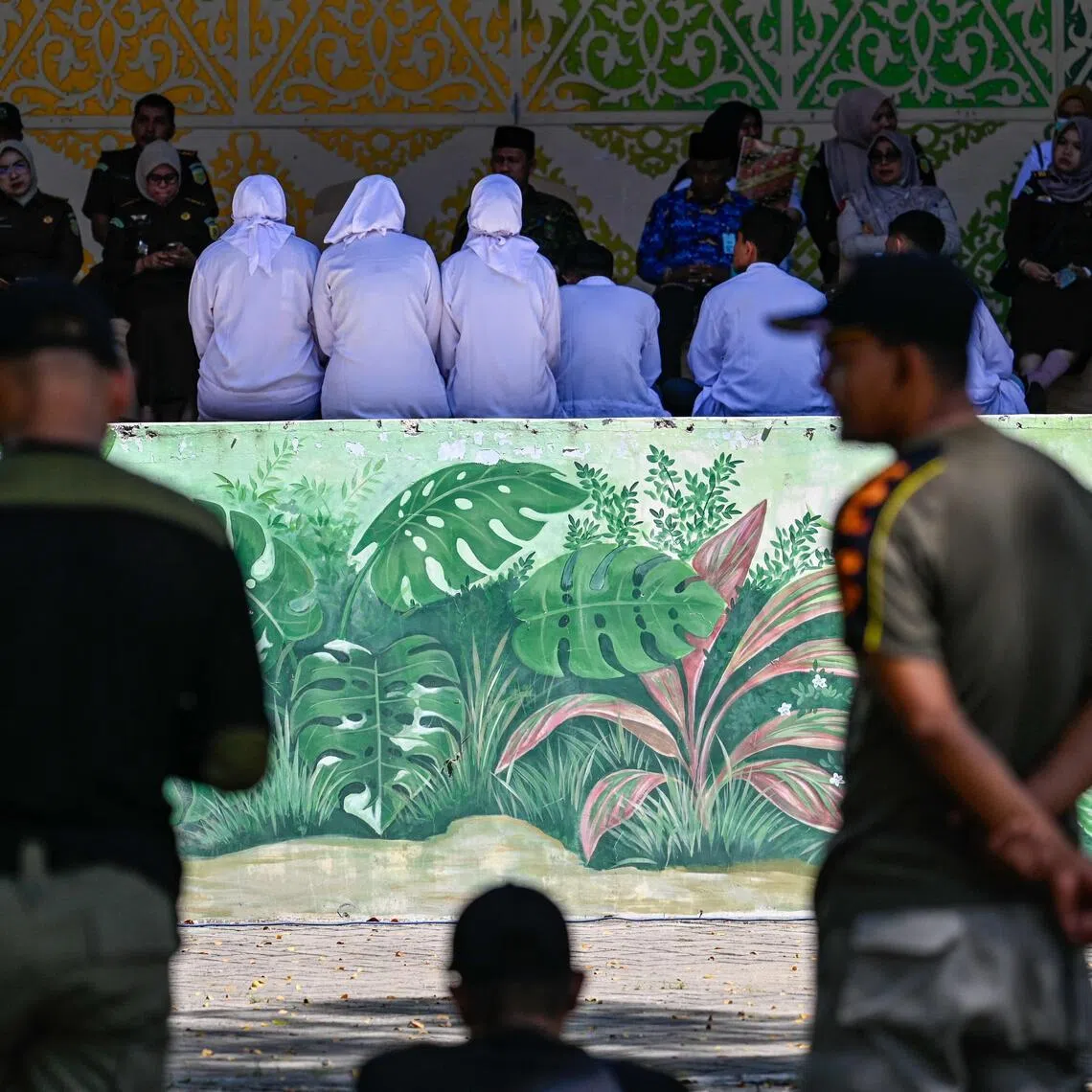 People deliver a speech before a public caning by members of the syariah police in Banda Aceh on Jan 29.