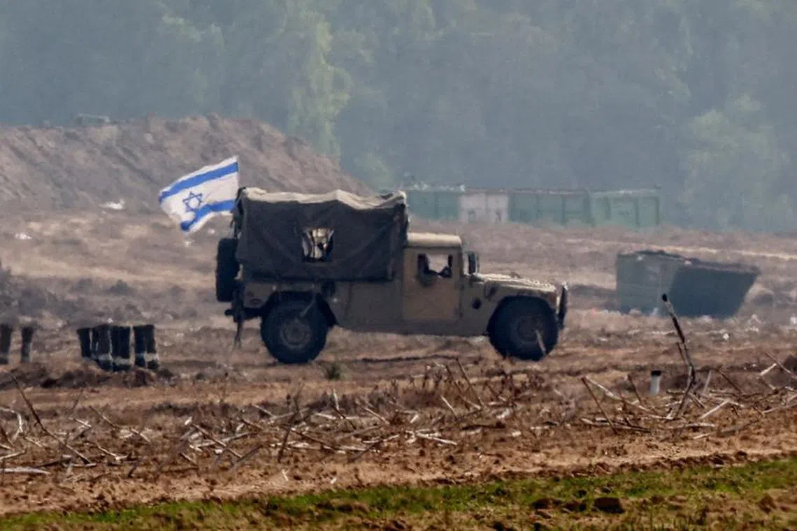 An Israeli flag flies on a military vehicle as the Israeli army operates at the border with Gaza, amid the ongoing conflict between Israel and the Palestinian Islamist group Hamas, as seen from southern Israel, December 5, 2023. REUTERS/Athit Perawongmetha