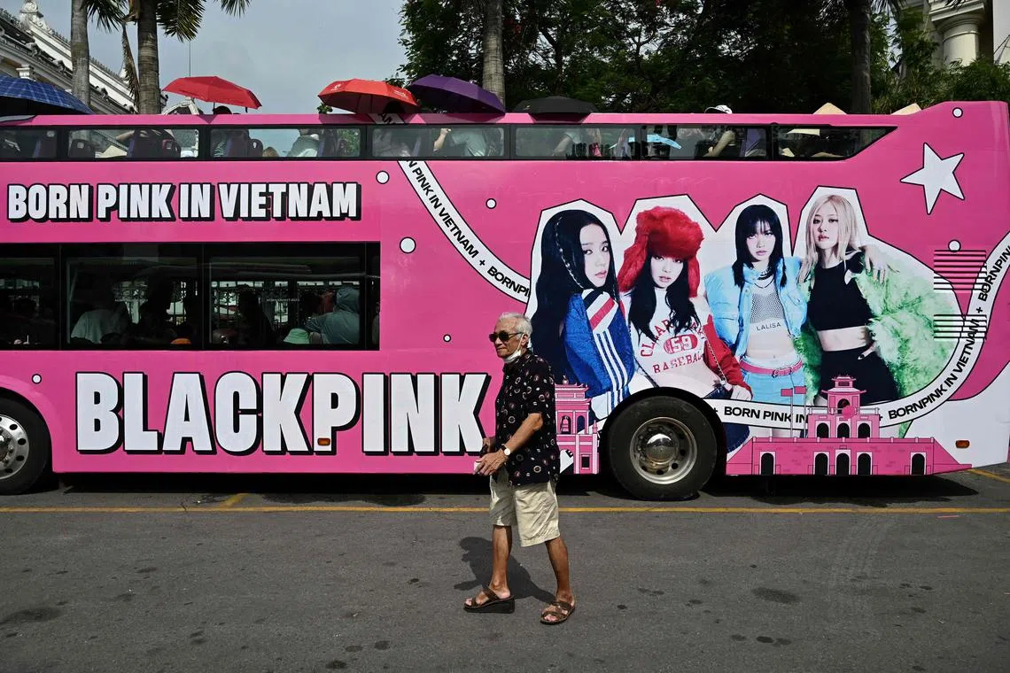 A man walks past a bus used for promotion for the BlackPink band on the eve of their two day concert in Hanoi on July 28, 2023.