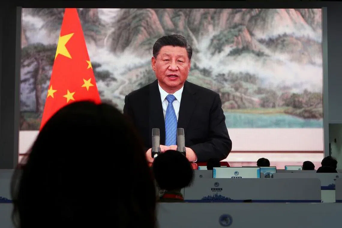 FILE PHOTO: Chinese President Xi Jinping is seen on a giant screen at a media centre as he delivers a speech via video at the opening ceremony of the China International Import Expo (CIIE) in Shanghai, China November 4, 2021. REUTERS/Andrew Galbraith/File Photo