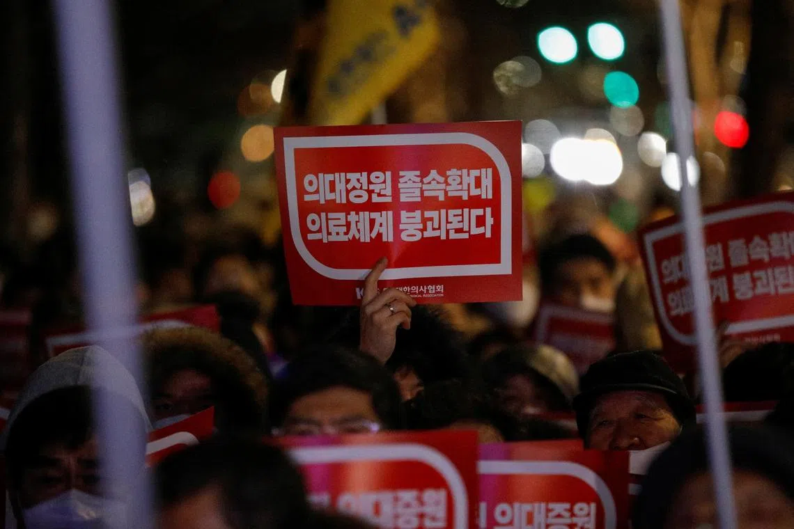 FILE PHOTO: A doctor holds a slogan in a protest against a plan to admit more students to medical school, in front of the Presidential Office in Seoul, South Korea, February 22, 2024. REUTERS/Kim Soo-Hyeon/File Photo