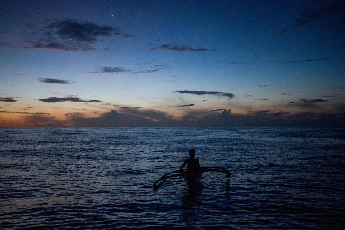 FILE PHOTO: A Filipino fisheman rows a boat during a trip near the disputed Scarborough Shoal, in Masinloc, Zambales province, Philippines, July 18, 2022.  REUTERS/Lisa Marie David/File Photo