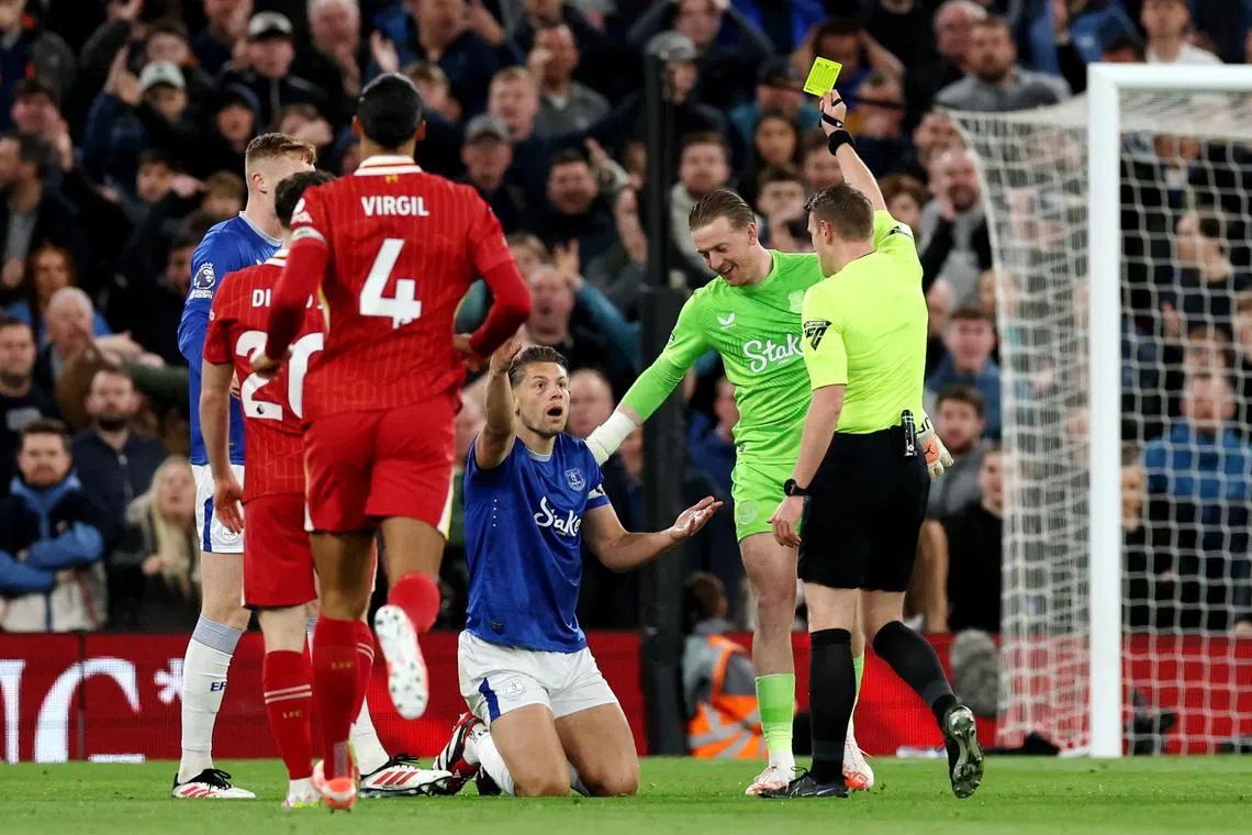 FILE PHOTO: Soccer Football - Premier League - Liverpool v Everton - Anfield, Liverpool, Britain - April 2, 2025 Everton's James Tarkowski is shown a yellow card by referee Samuel Barrott REUTERS/Phil Noble/File Photo