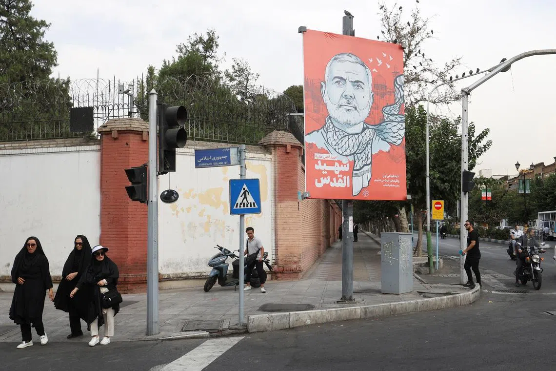 People walk past a banner with a picture of late Hamas leader Ismail Haniyeh in a street in Tehran, Iran, August 12, 2024. Majid Asgaripour/WANA (West Asia News Agency) via REUTERS  ATTENTION EDITORS - THIS PICTURE WAS PROVIDED BY A THIRD PARTY
