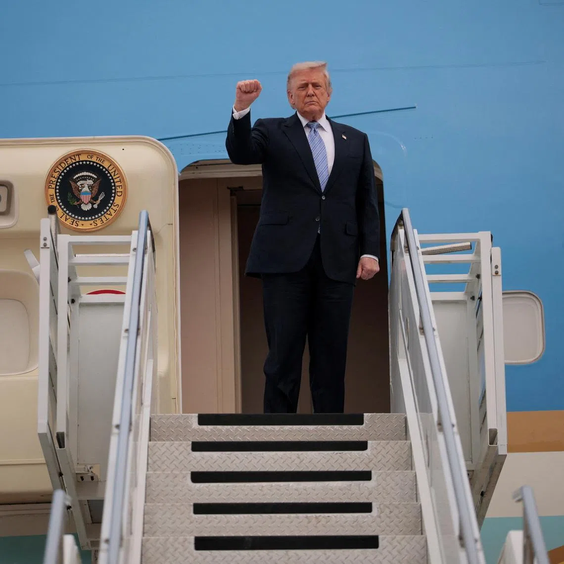 US President Donald Trump gestures as he departs Beijing Capital International Airport aboard Air Force One, in Beijing, China, on May 15.