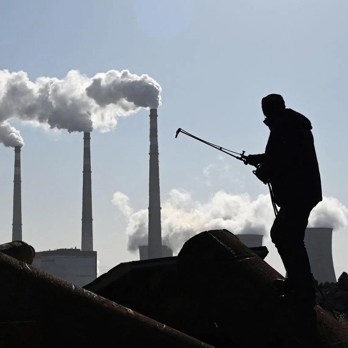 A man works near a coal power plant at Zhangjiakou in China's northern Hebei province in this November 2021 file picture. PHOTO: AFP