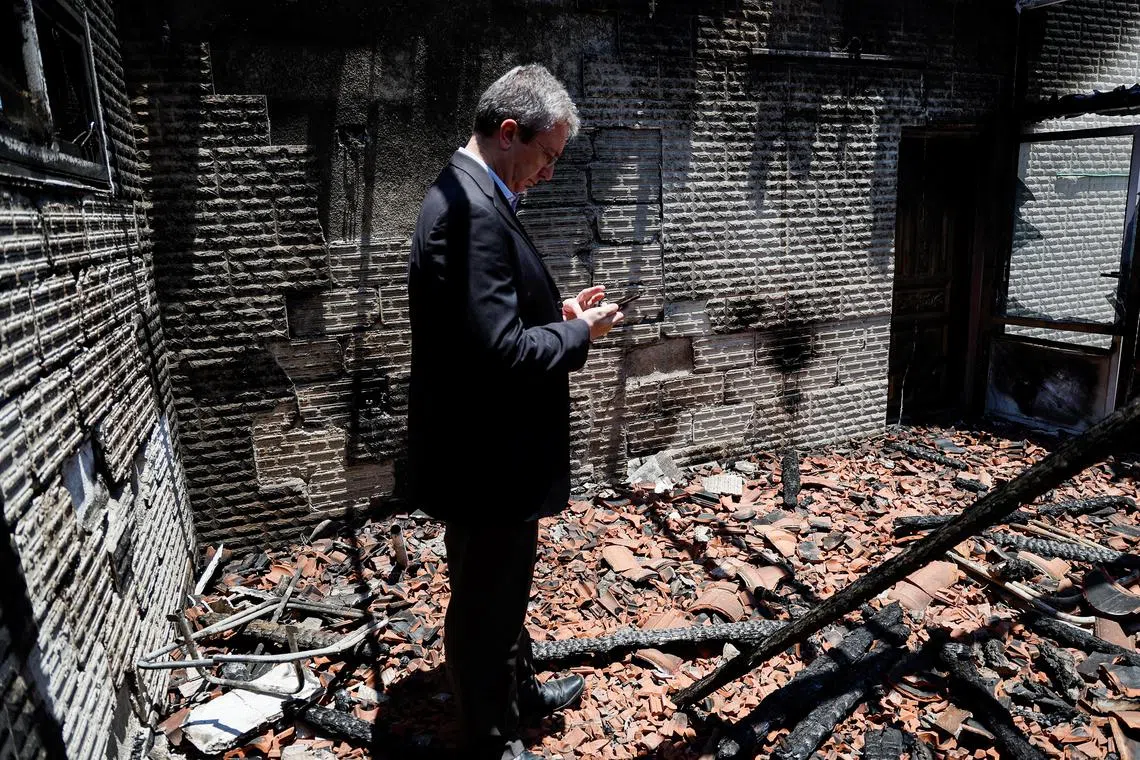 A European diplomat checks a Palestinian building that was torched by Israeli settlers, during a visit to the Israeli-occupied West Bank.
