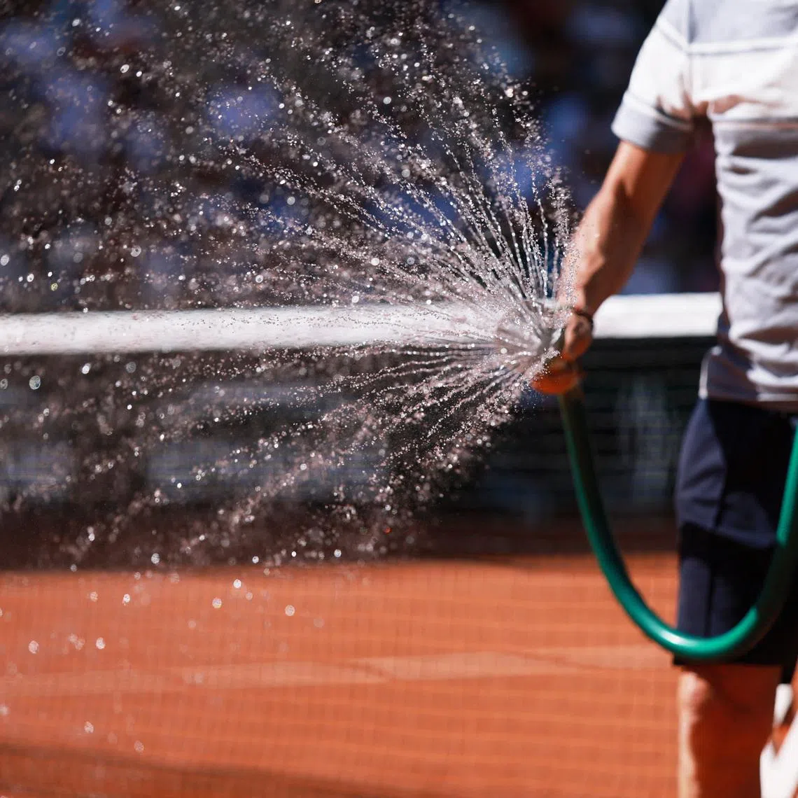 Tennis - French Open - Roland Garros, Paris, France - May 27, 2026 A worker waters the court during the second round match between Ukraine's Yuliia Starodubtseva and Kazakhstan's Elena Rybakina REUTERS/Stephanie Lecocq