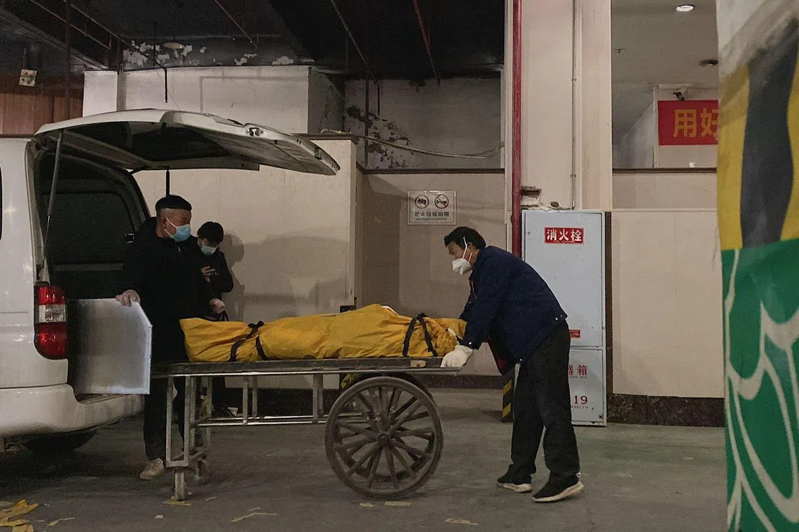 Funeral workers loading a body to a cart to be cremated at a crematorium in Chongqing, China, on Dec 22, 2022.