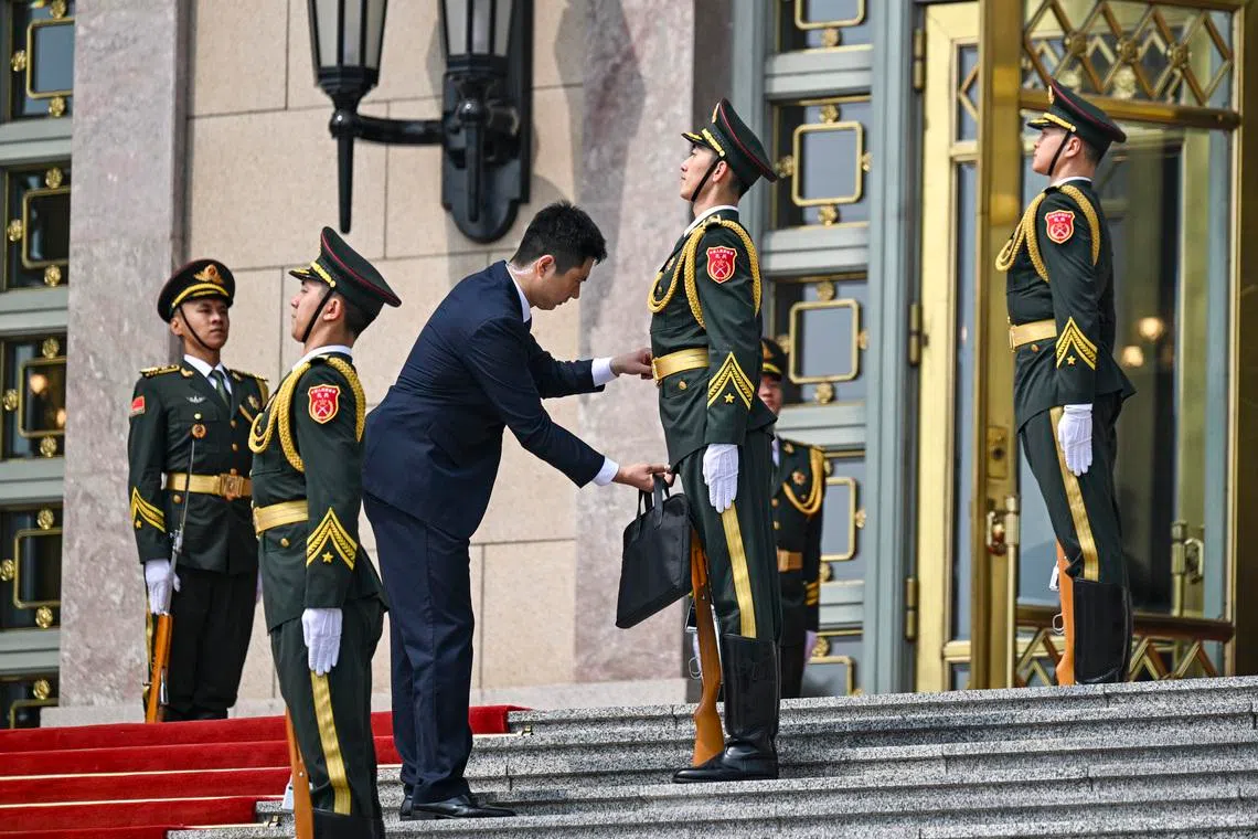 A uniform is adjusted before President Xi Jinping of China welcomes President Donald Trump to the Great Hall of the People in Beijing during their two-day summit, on May 14.