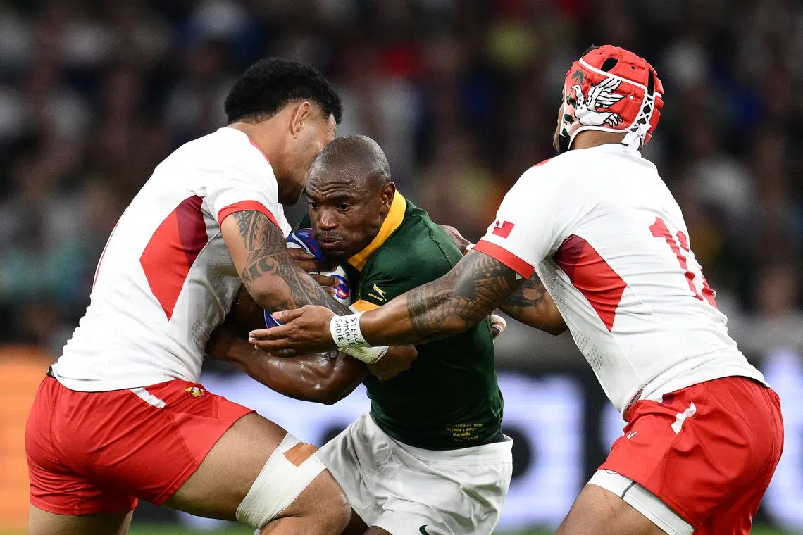 South Africa's Makazole Mapimpi (centre) fights for the ball during the World Cup match against Tonga on Oct 1.