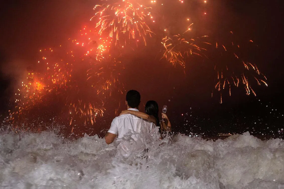 People watching the traditional New Year's fireworks from the water at Copacabana Beach in Rio de Janeiro, Brazil, on Jan 1, 2024. 